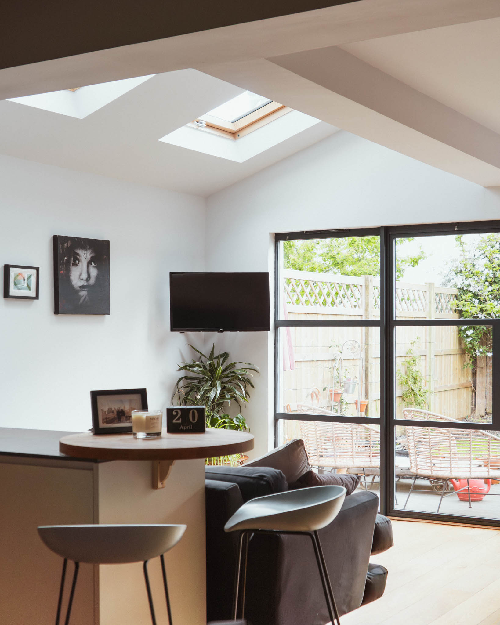 Dining area with steel-framed doors open to garden, rooflight above and exposed brick, side return extension Bristol