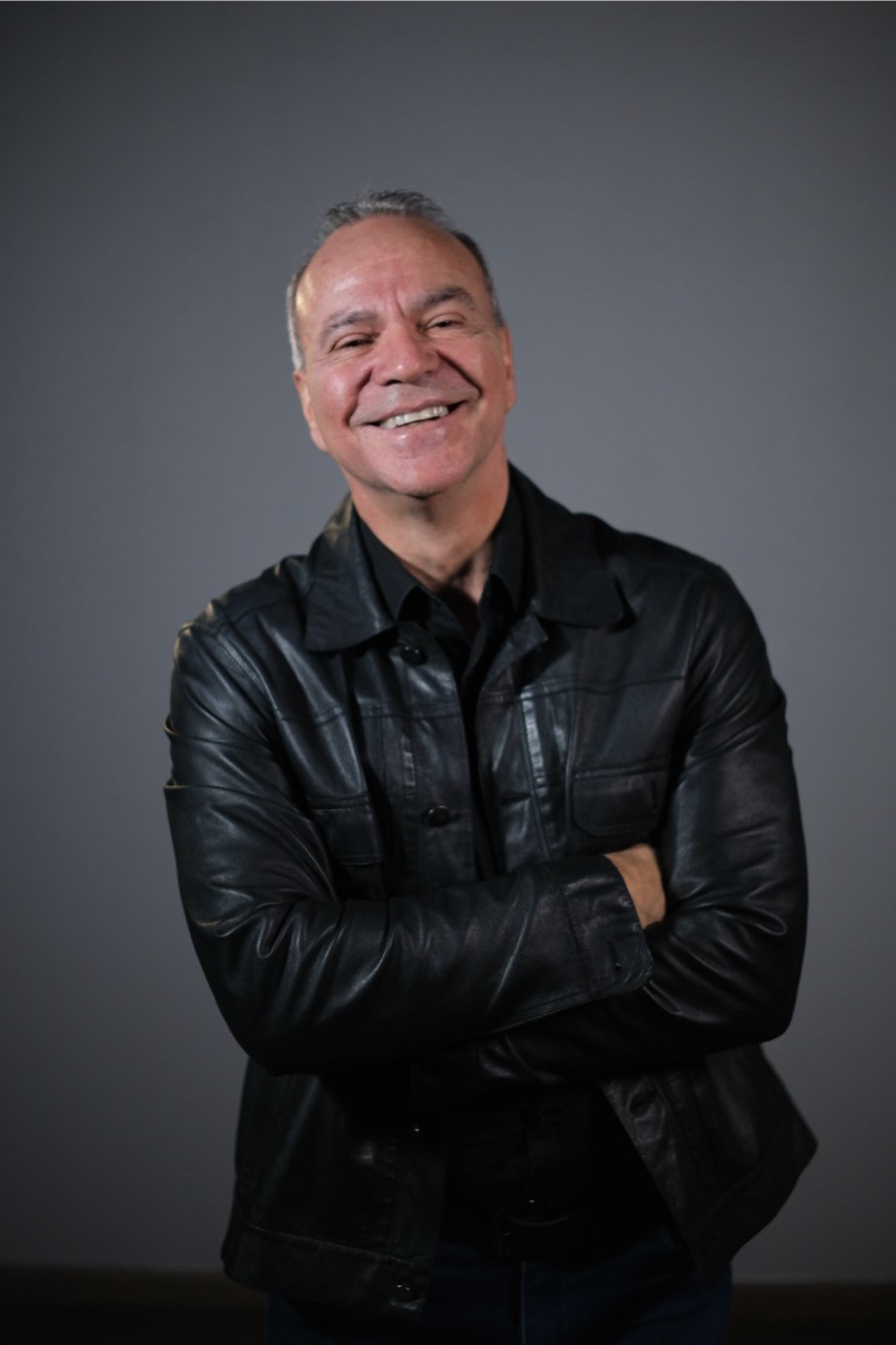 Alejandro Ochoa, Founder, posing against a dark background.