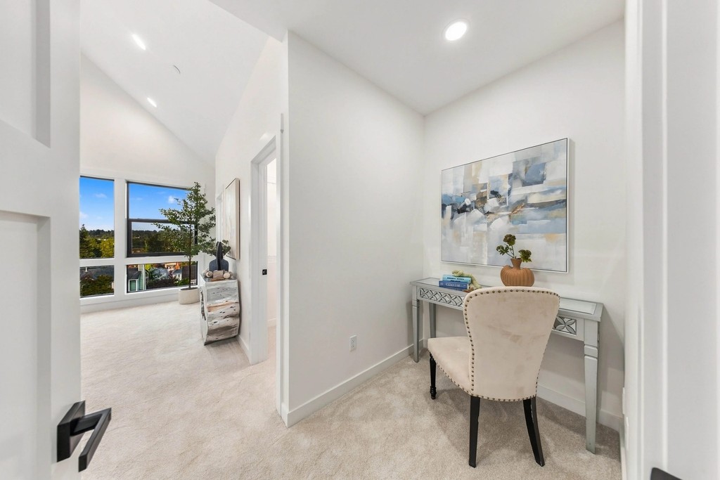 Vaulted primary suite vestibule with a vanity desk