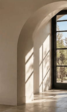 Arched plaster doorway with soft daylight on a stone floor