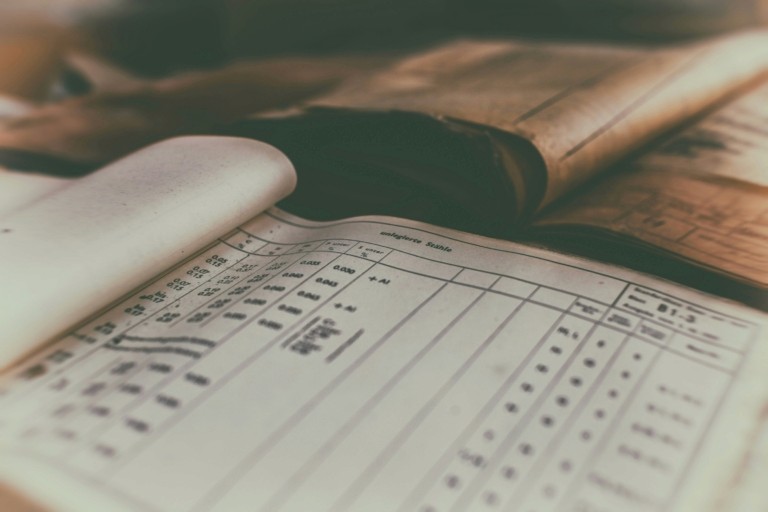 Open ledgers and handwritten record books with columns, representing formal documentation and whistleblowing policy procedures in care organisations