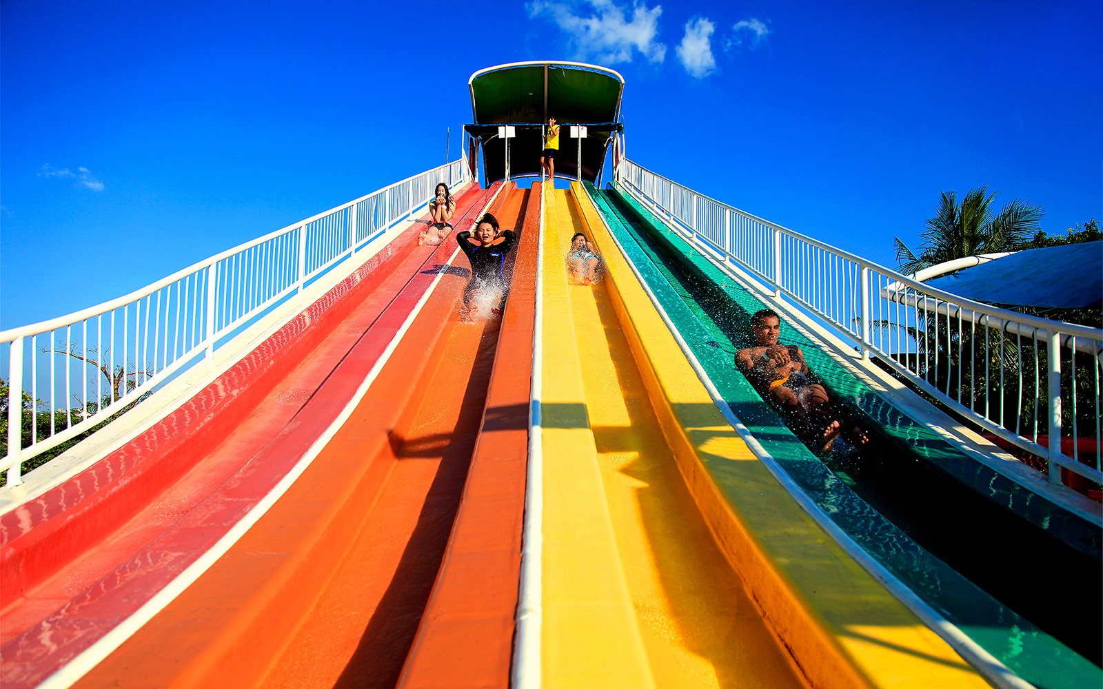 Vizitatori care se bucură de toboganele acvatice colorate la Siam Amazing Park, Bangkok.