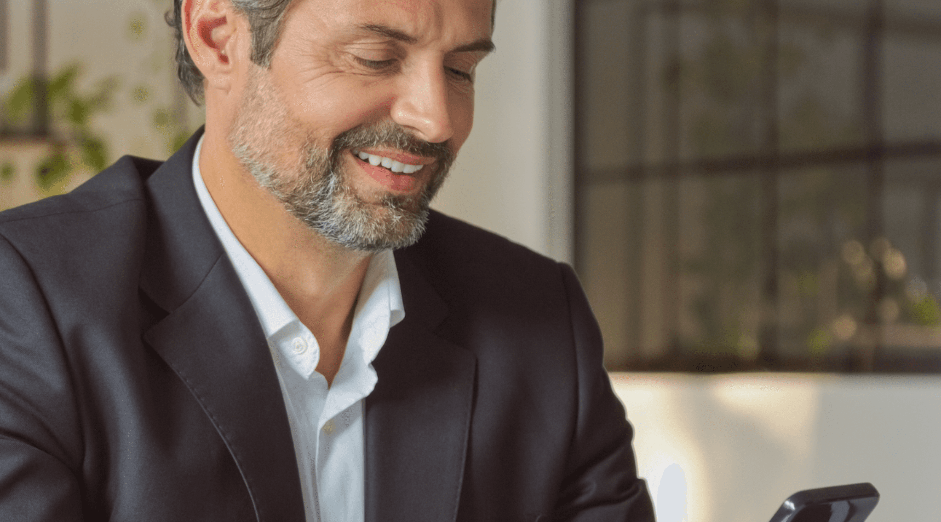 Young man in a formal outfit with a striped shirt, grey tie, and black coat. The tone is serious and professional, emphasizing subdued elegance.