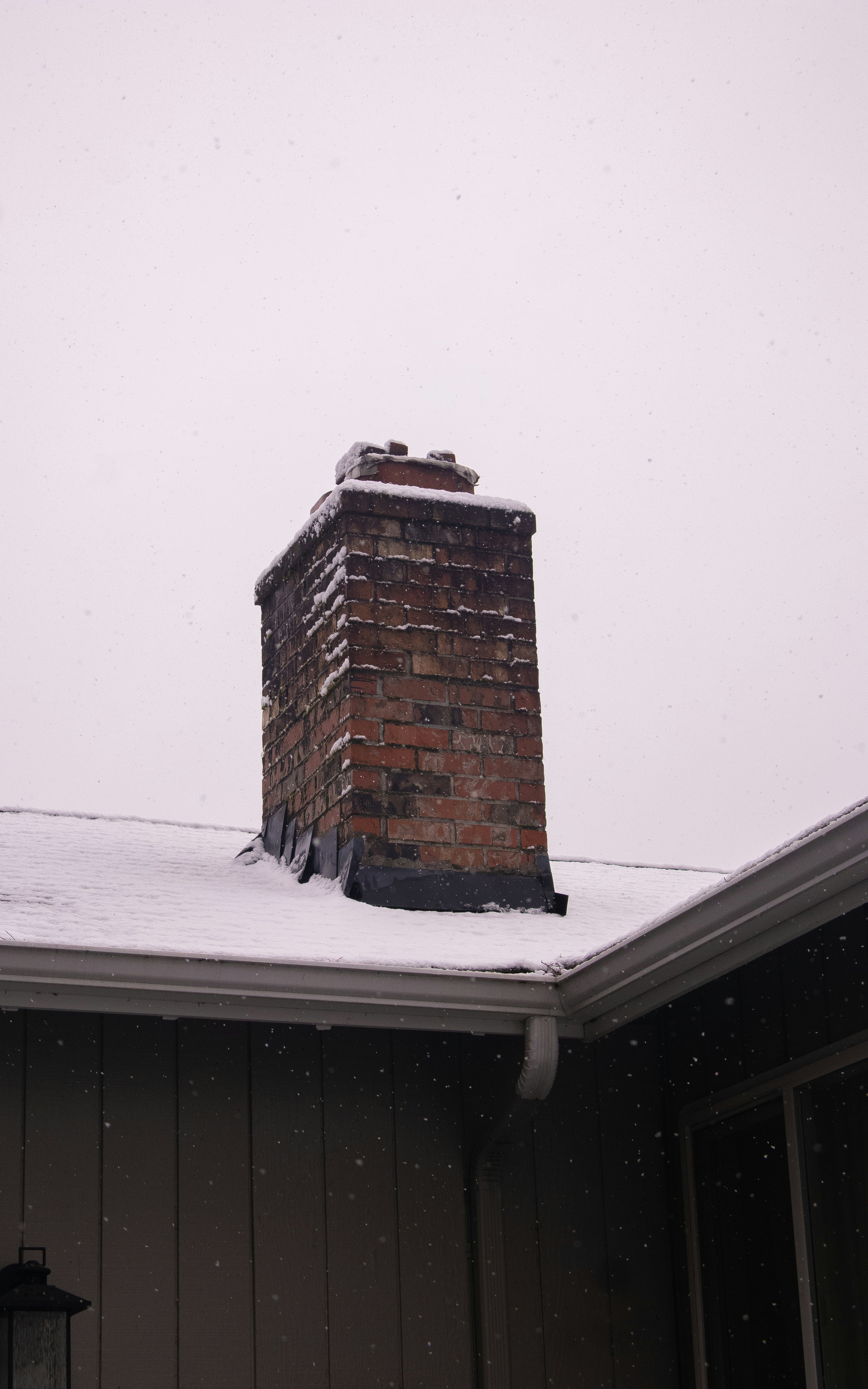 A chimney covered in snow on a snowy day