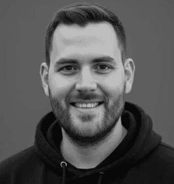 A woman with a red bow headband and bright orange and blue clothing poses against a teal and orange geometric background. Her expression is confident.