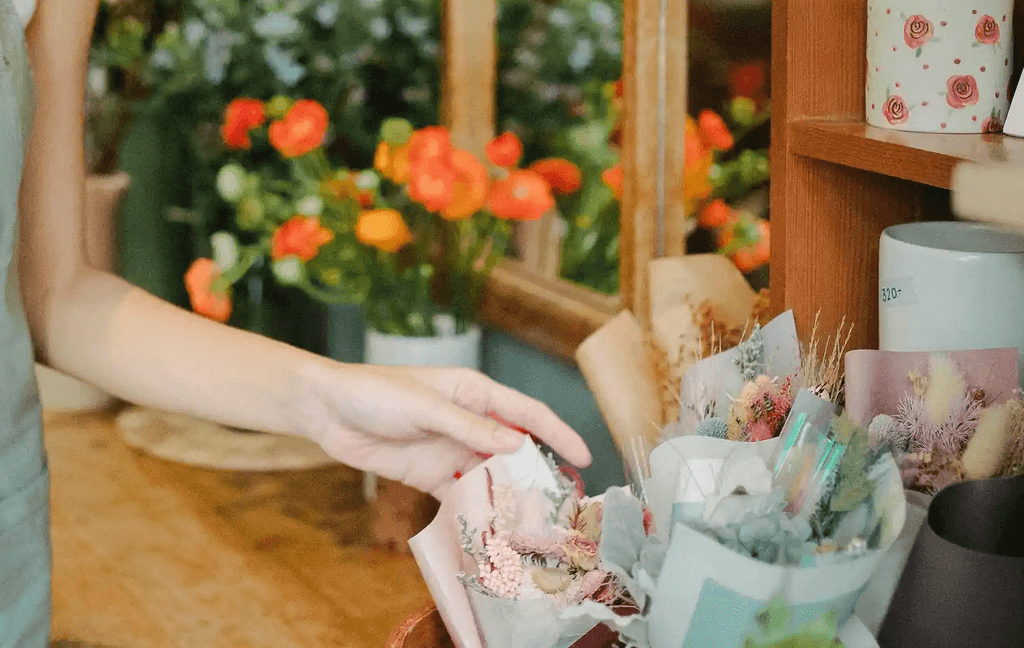 Person picking flowers from a store