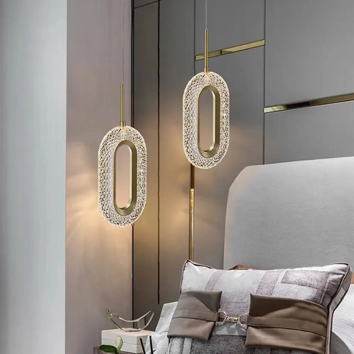 Ovated Gold Ring LED Pendant Light hanging from the ceiling over a bed.