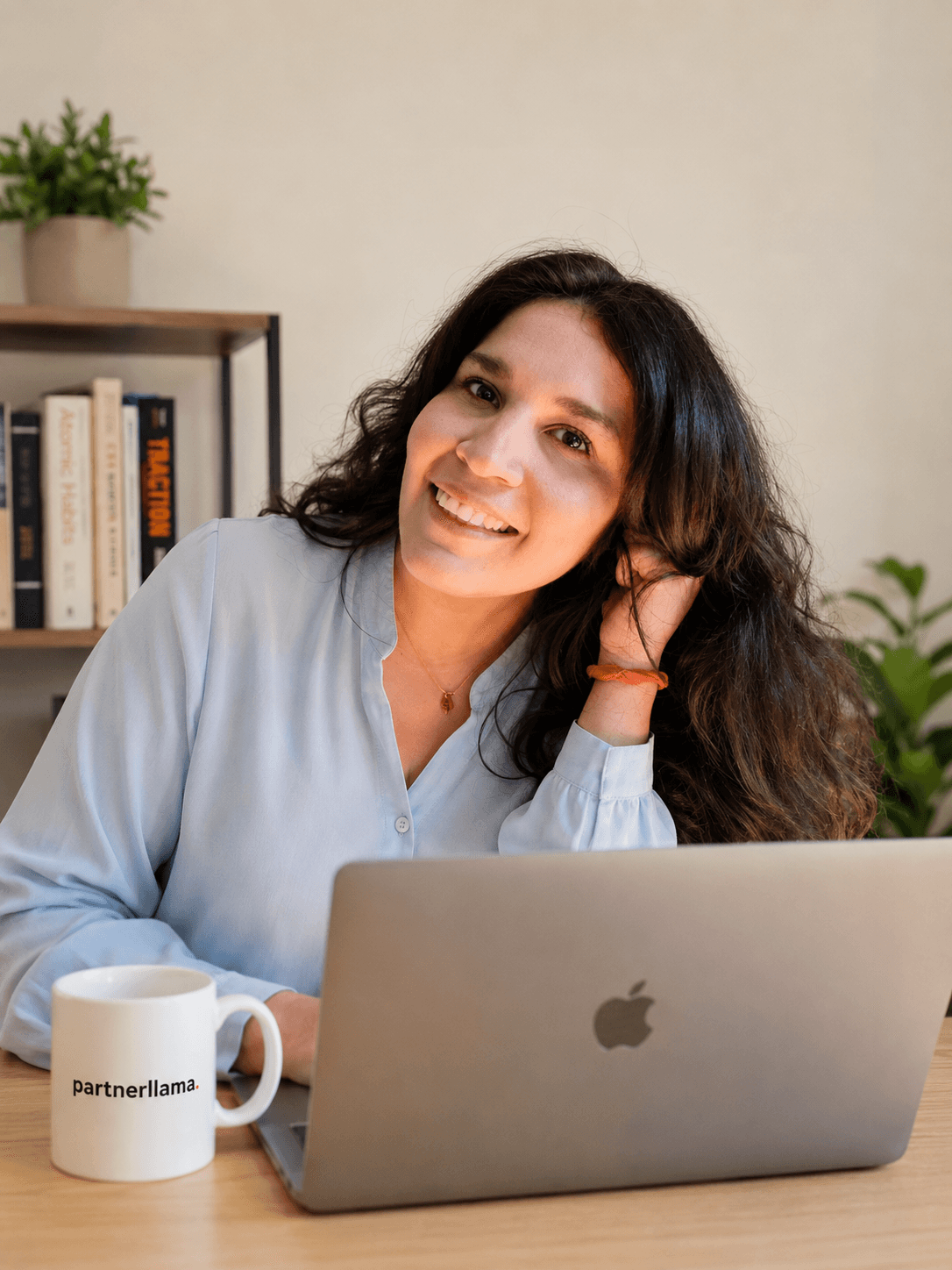 Woman with glasses working focused on laptop at wooden desk