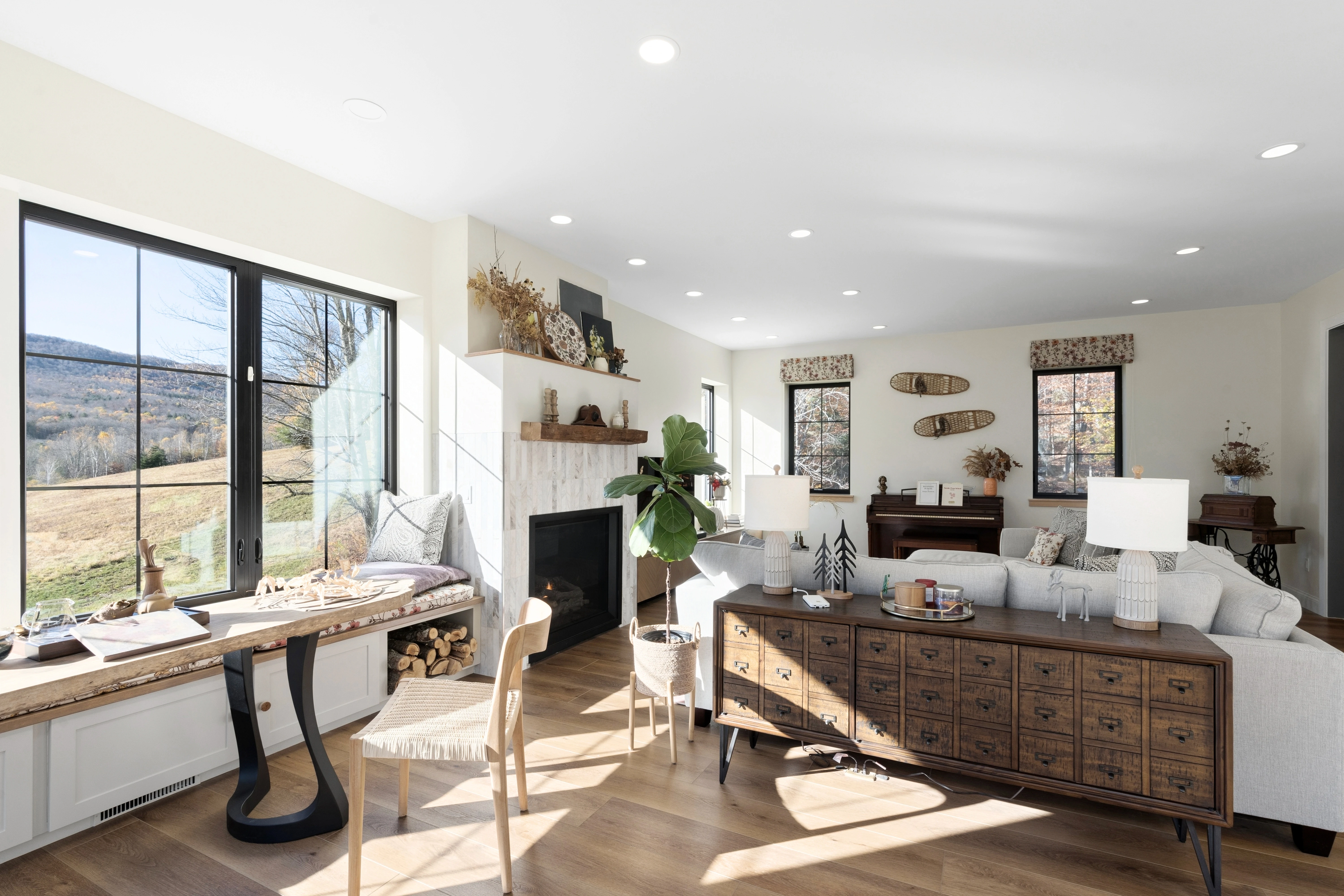 Edited real estate photo of a living room with a home office desk and mountain view
