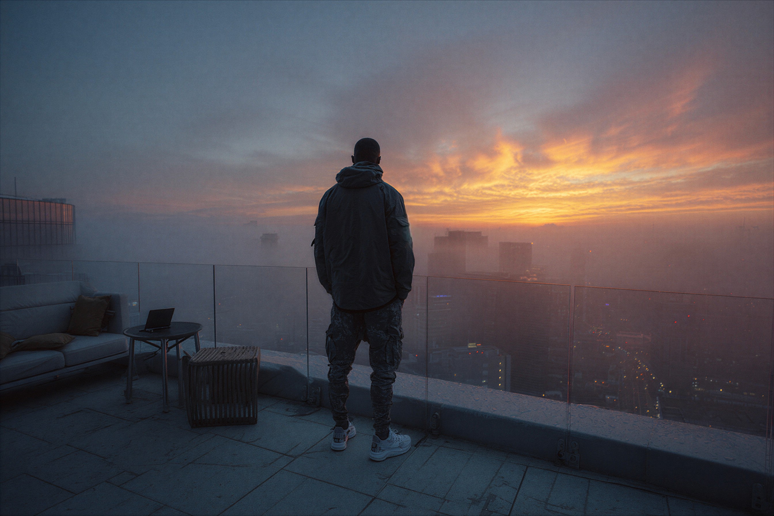 Three people sitting on a couch in a room looking at mobile devices