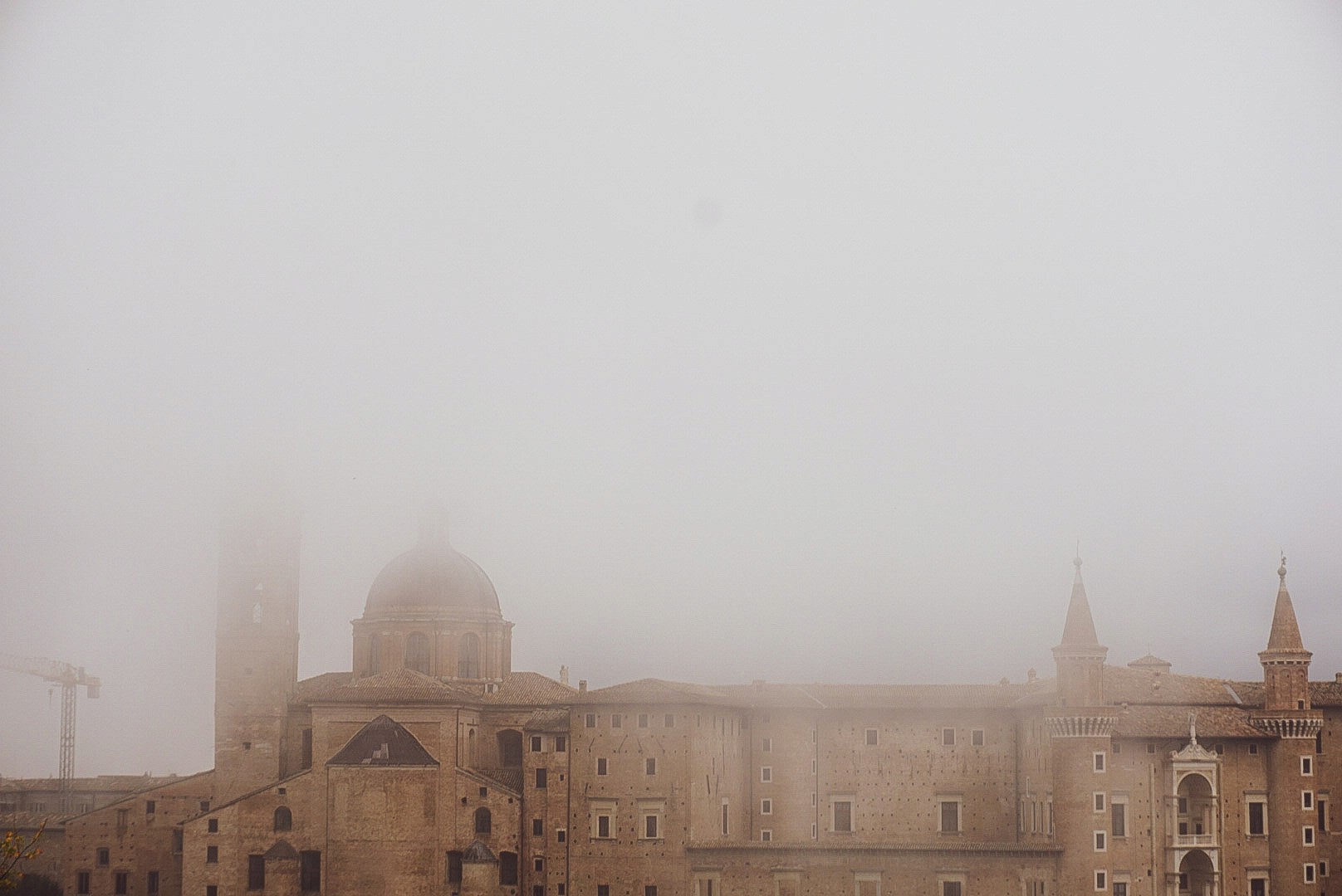 Historic Roman architecture fading into a thick morning fog, photographed by Janice Chen.