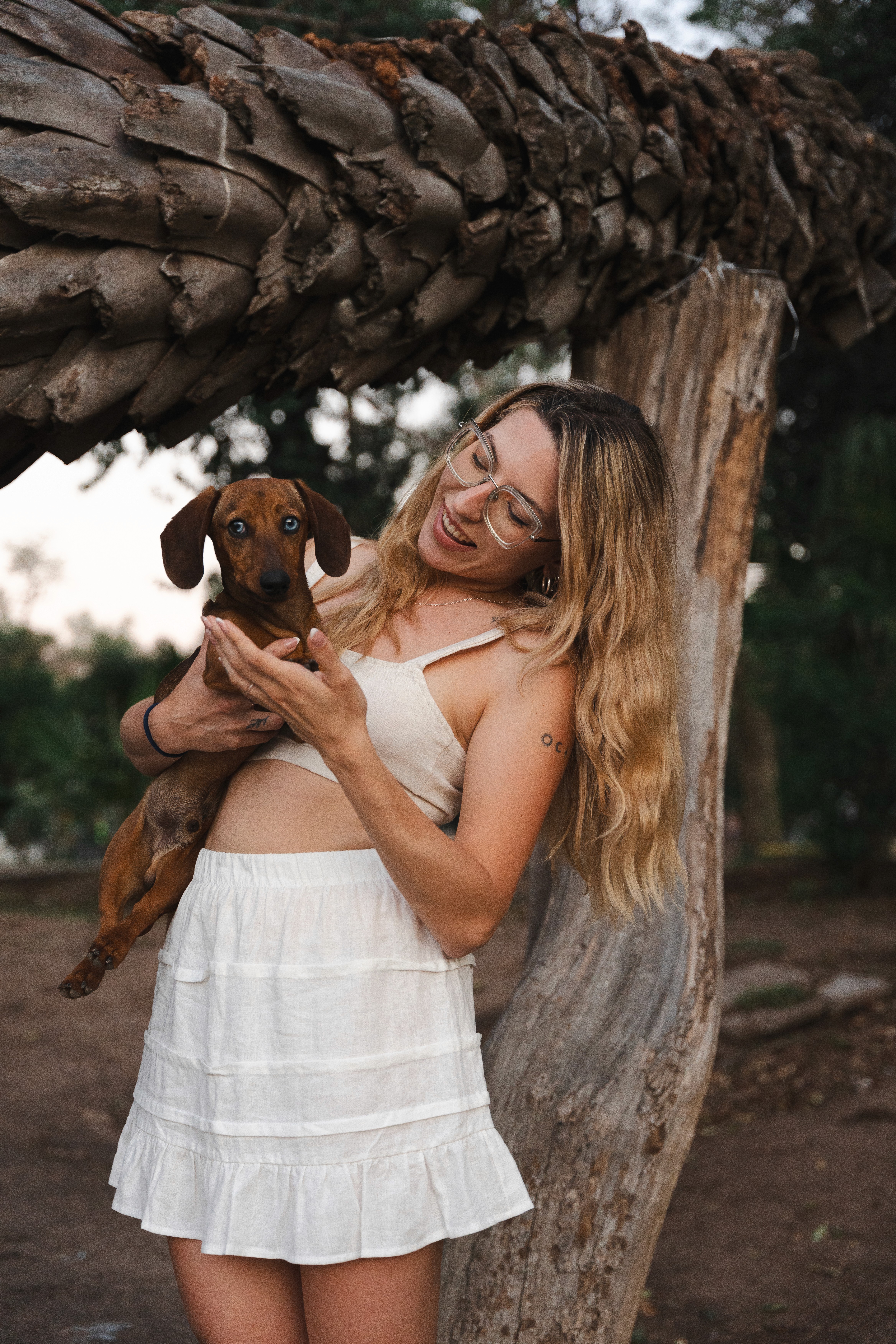 A close-up of a pink cocktail in a martini glass, set against a nighttime background with soft, blurred colors.