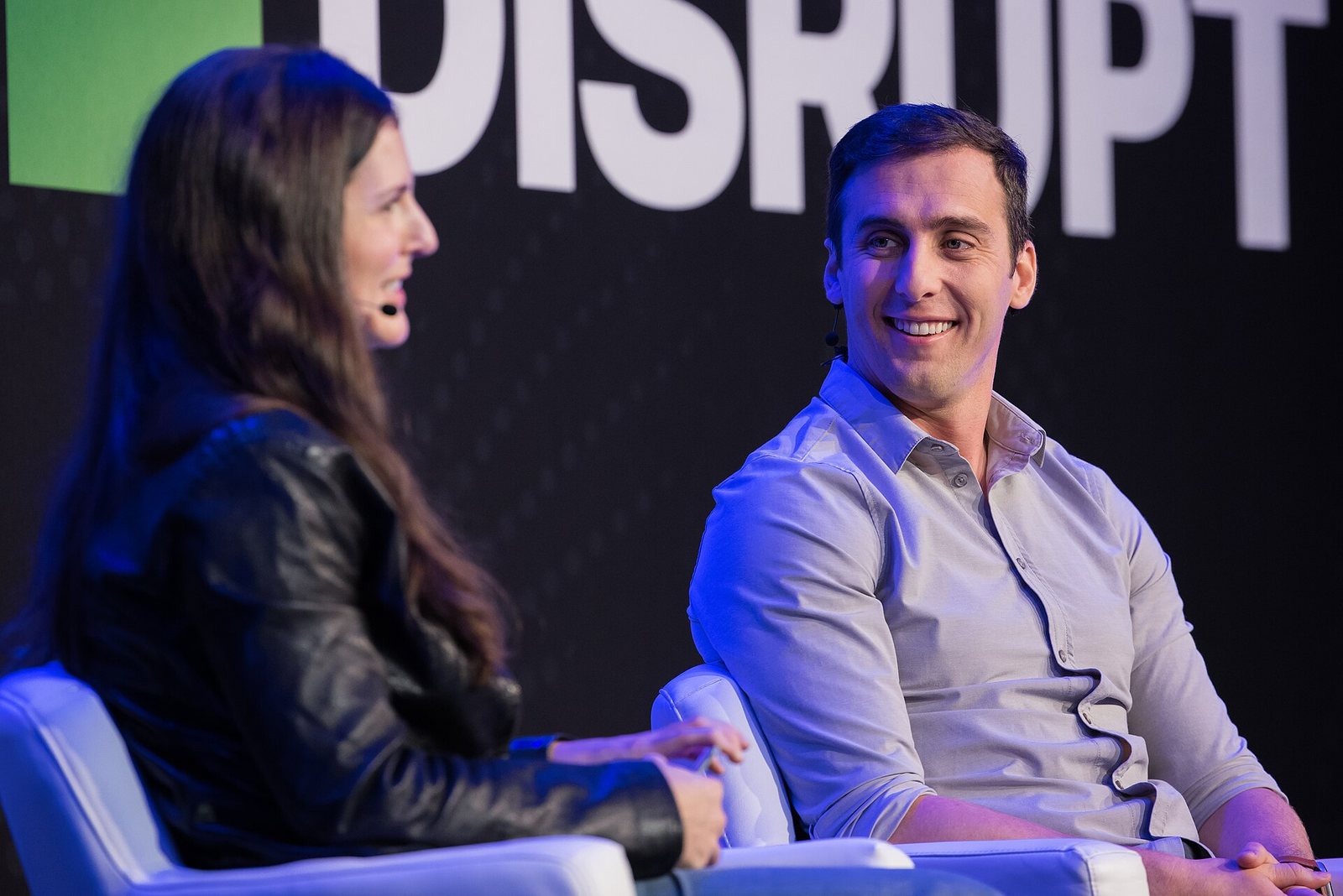 Two speakers seated on stage in front of a large DISRUPT sign at TechCrunch Disrupt 2025 in San Francisco