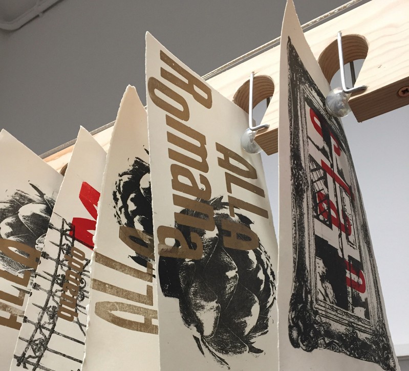 A photo of different fresh paper imprints that are hanged to dry.