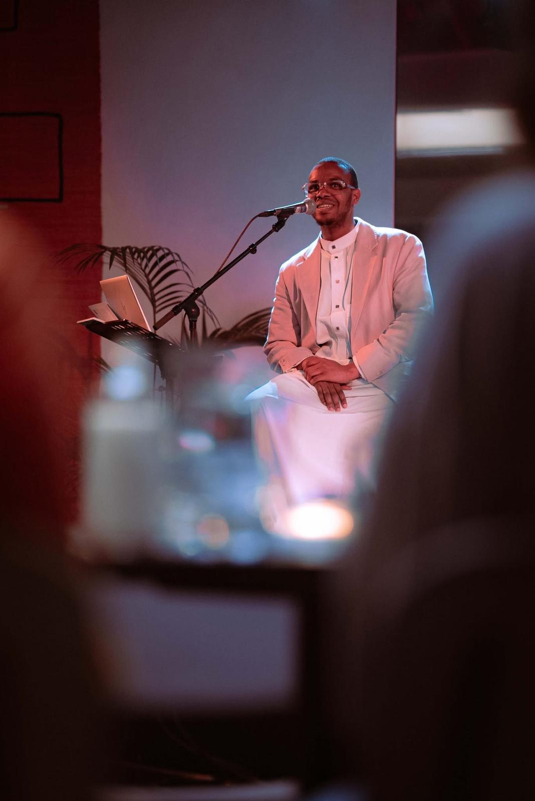 Close-up of lush, dark green leaves, some glossy and wet, against a muted background.