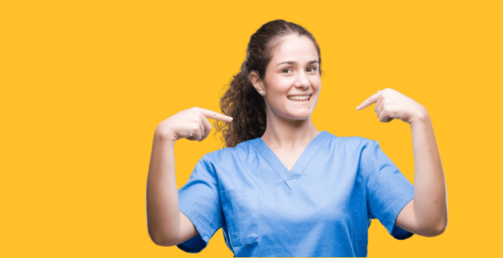 Smiling healthcare worker in scrubs pointing at herself on a yellow background