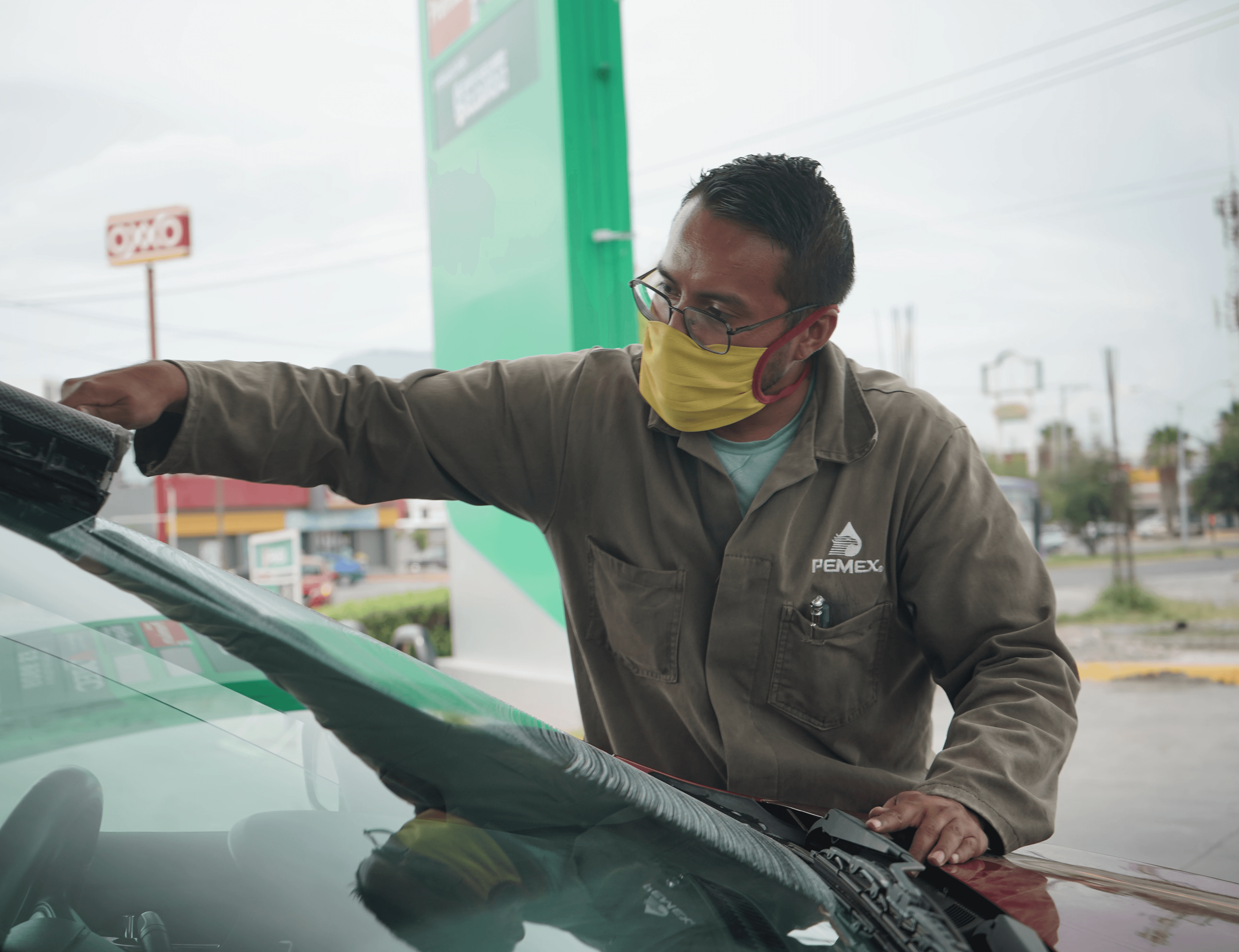 Modern living room with abstract art, beige sectional sofa, indoor plants, and large windows.