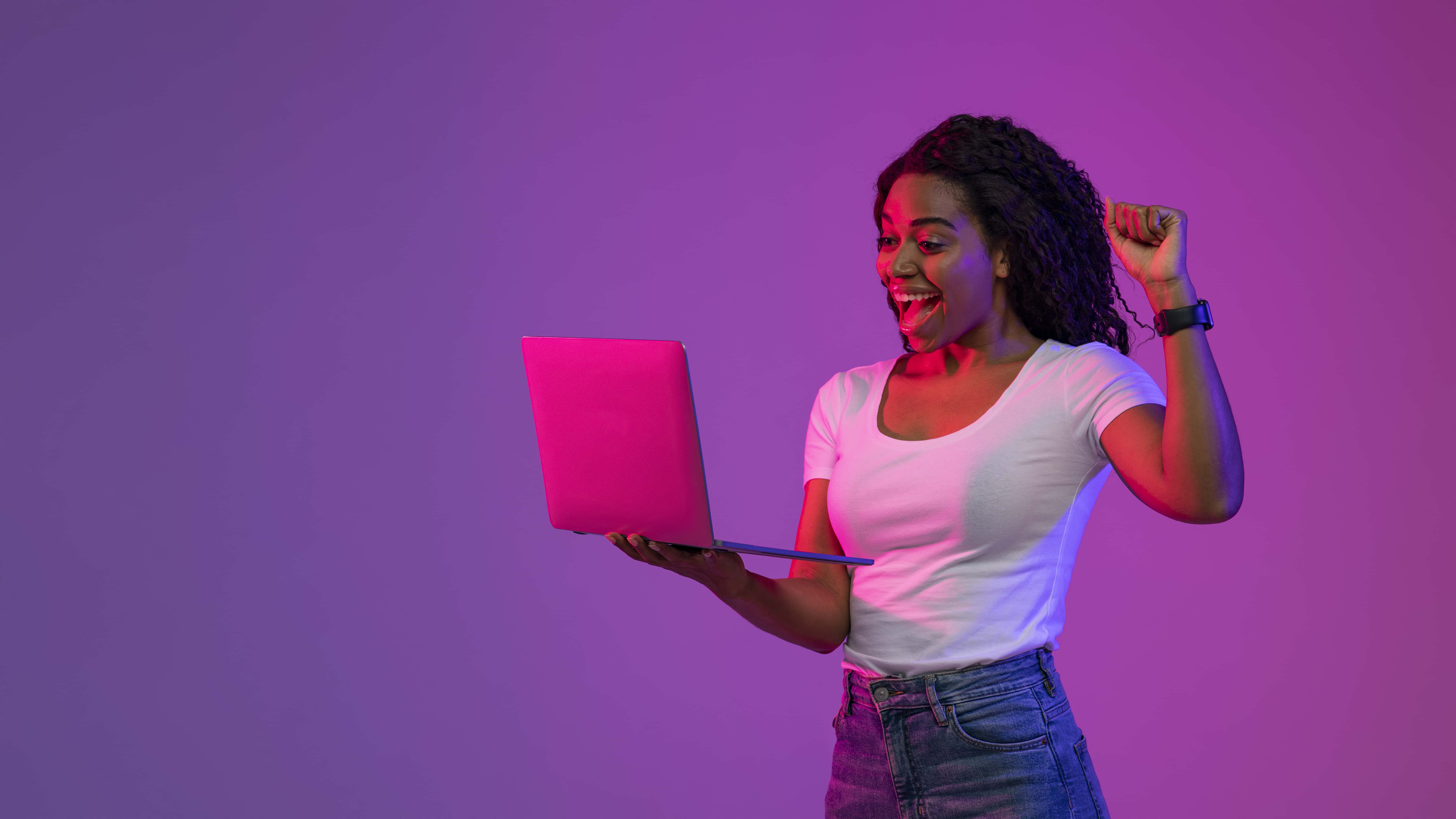 Women holding a laptop and cheering