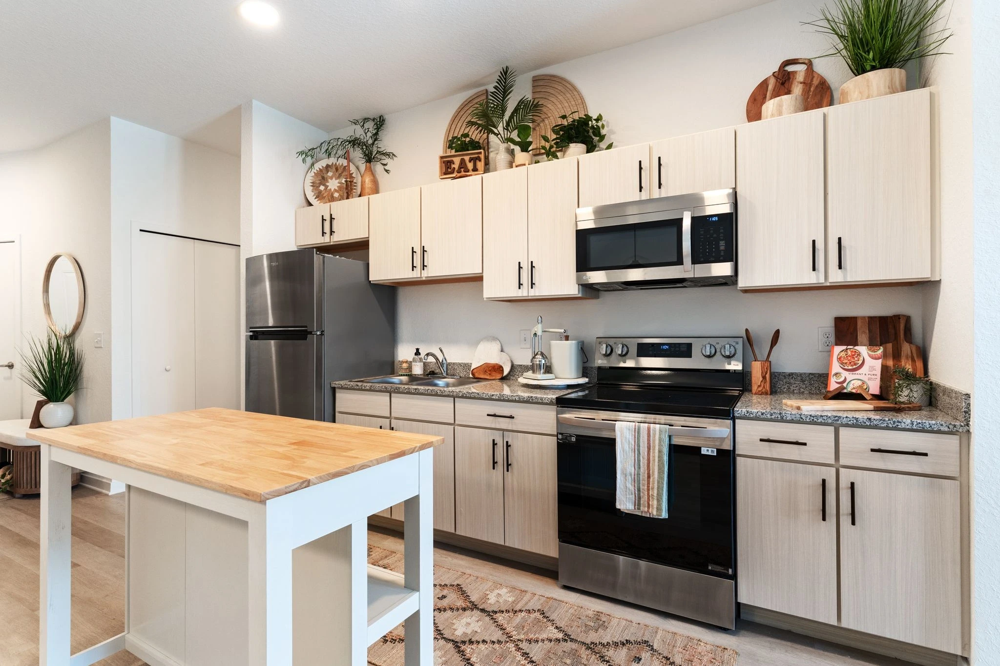 A modern kitchen featuring stainless steel appliances and elegant wooden countertops, showcasing a blend of style and functionality.