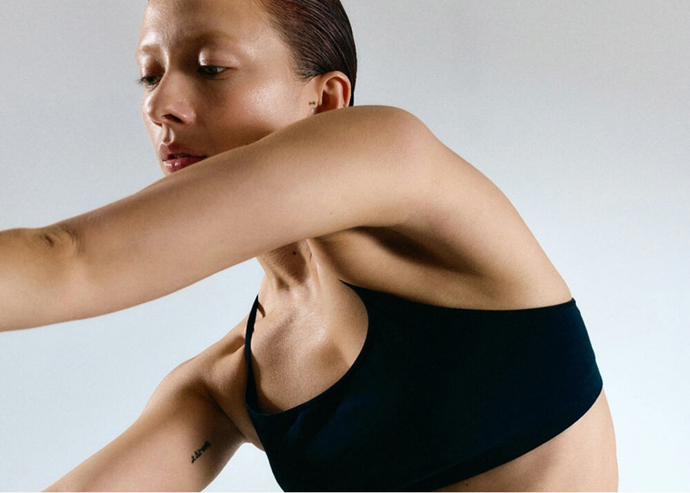 Close-up portrait of a woman in a black sports bra.