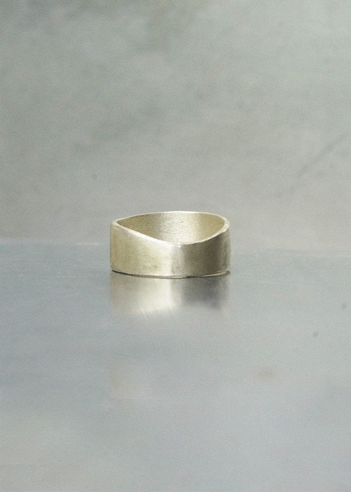 Silver ring on a gray surface with a neutral background