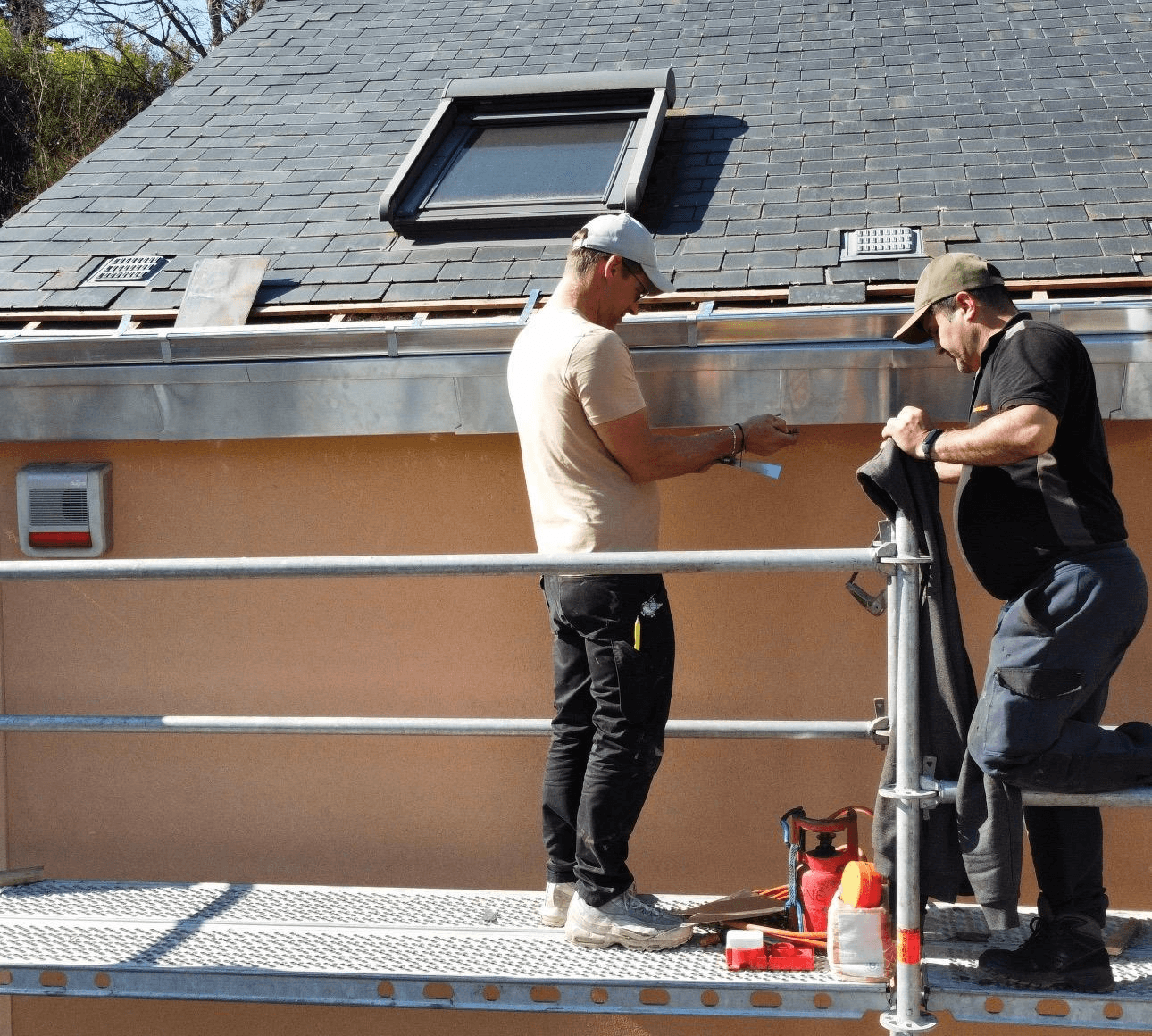 a man working on a roof with a power drill
