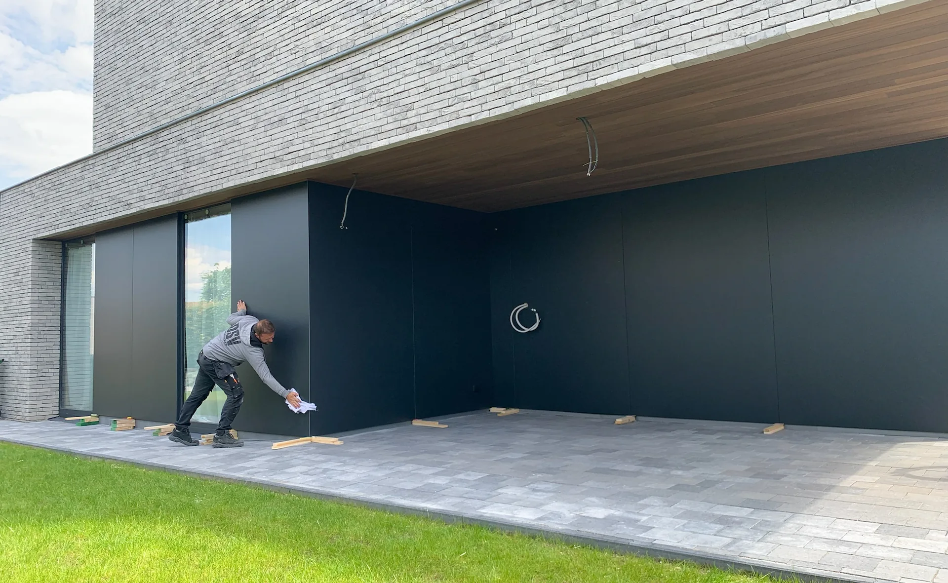 A man doing a final clean on a modern house.