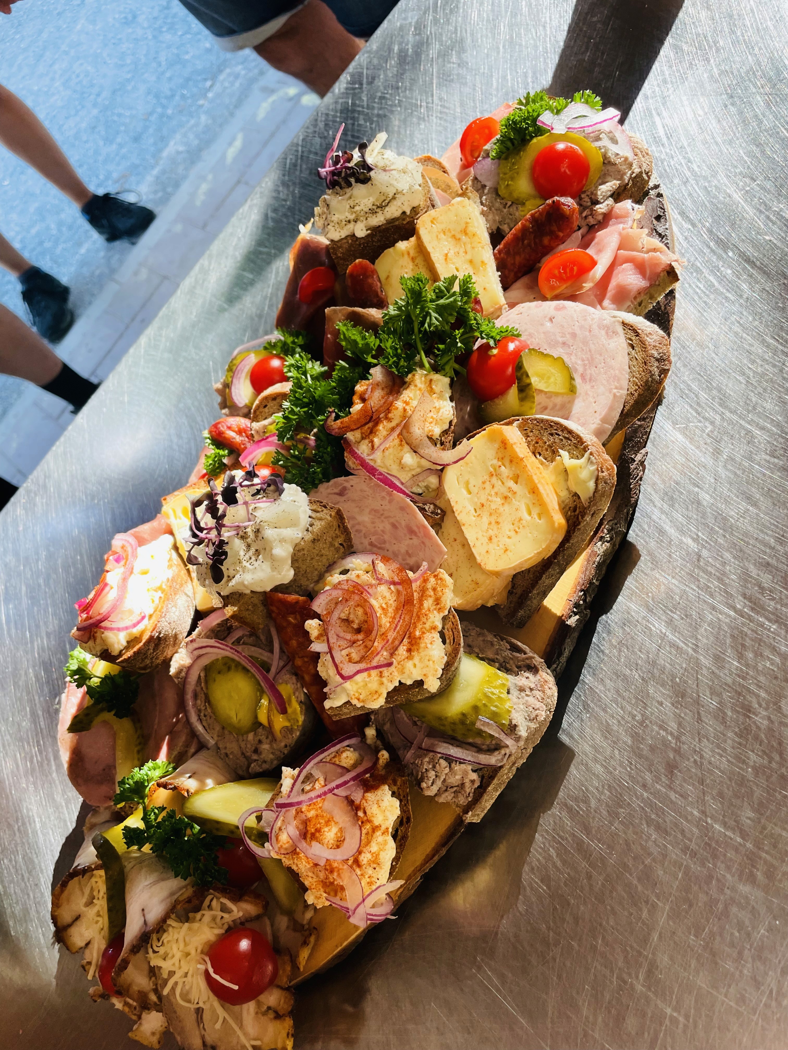 Smiling young man with short hair poses against a dark background, wearing a green button-up shirt.