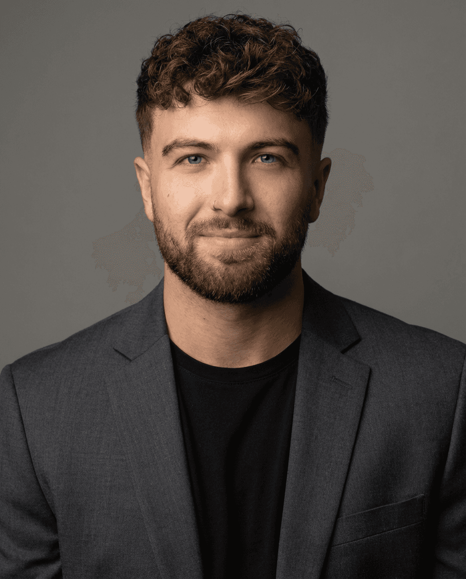 Portrait of a woman with straight long hair, in a dark t-shirt, set against a neutral backdrop.
