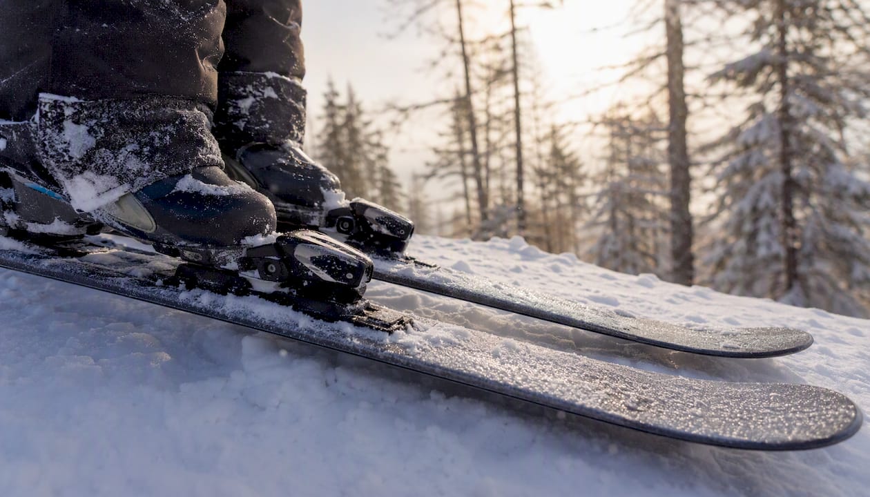 Cat-Skiing and Freeriding offers a visual reference.
Who is cat skiing suitable for?
Many operators look for confident off-piste and powder ability rather than a particular resort piste grade. You should be comfortable controlling your speed on ungroomed snow, making linked turns in changing conditions and skiing or riding for a sustained day. The selected operator sets the actual minimum standard, terrain choices and any training requirements.
Be candid about your experience when making an enquiry. If deep snow, trees or uneven snow feel unfamiliar, time with an instructor at a lift-served resort is a sound preparation step. Guides can select terrain appropriate to the group, but technical terrain is more rewarding when your basic movement in powder already feels natural. One general ability comparison is described as equivalent to confident advanced intermediate terrain, while Beginners Guide to Cat Skiing (Key Tips For First Timers) - newtoski provides a longer first-timer perspective.
Fitness matters too, although there is no universal training plan for a cat-skiing trip. Build general leg strength, balance and aerobic endurance in the weeks before travel, and arrive rested. If you have a health concern that could affect strenuous cold-weather activity, speak with a qualified clinician before making plans.
What happens during a cat-skiing day?
The day normally begins with meeting the guides, reviewing the plan and preparing equipment. From there, the pattern is simple: travel uphill by snowcat, ski or ride a guided descent, regroup, and repeat. Group size, guide arrangement, ascent time, meal arrangements and number of descents differ considerably between operators, terrain and weather.
Rather than planning around a fixed run count, focus on the quality of the day’s terrain, the group’s pace and the prevailing conditions. Some published first-time accounts refer to 8 to 12 runs per day, but it is only an example, not a promise for any particular trip. The same principle is explored in Your Guide to Cat Skiing: The Need-To-Know - Nonstop Snow.
The snowcat is also the day’s mobile base between descents: a place to travel together, adjust layers and listen to the guide’s next instructions. Pace yourself from the first run. Smooth, controlled skiing usually makes for a stronger afternoon than treating the opening descents as a sprint.
Avalanche safety and required equipment
Cat skiing takes place in mountain terrain where hazards remain real. Professional guiding, terrain selection, briefings and equipment checks are important parts of a managed day, but they do not remove risk. At Altai Mountains Resort, the activity information describes safety briefings, equipment checks, avalanche equipment and training, communication and emergency protocols; the exact plan for a particular departure should be discussed during booking.
Avalanche Canada’s equipment guidance says that everyone travelling in avalanche terrain needs a transceiver, shovel and probe, along with training and regular practice. Avalanche.org’s rescue-equipment guidance identifies the same core tools and stresses knowing how to use them. A useful practical reference to avalanche transceiver, probe and shovel can supplement, but never replace, the briefing and procedures given by your guides.
Before departure, establish which equipment is supplied, what you need to bring, how the group will communicate and what happens if someone is injured or separated. Follow the guides’ instructions throughout the day, including their decisions about route choice, spacing and regrouping. Avalanche awareness and companion-rescue training are available through organisations such as Avalanche Canada and are valuable preparation for winter backcountry users.
This article provides general travel information, not medical, avalanche or personal safety advice. Conditions and procedures change daily; rely on the briefing and instructions provided for your specific trip.
What to bring and what to confirm
Bring the outerwear and personal items you would use for a full day in winter mountain conditions: waterproof outer layers, insulating layers, gloves, goggles, helmet, sun protection, water and snacks. Ski or snowboard equipment should suit the expected snow and your own ability. A rental technician or the operator can help you choose an appropriate setup rather than relying on a fixed ski-width or length rule.
![Powder skis and ski boots prepared for a day on snow