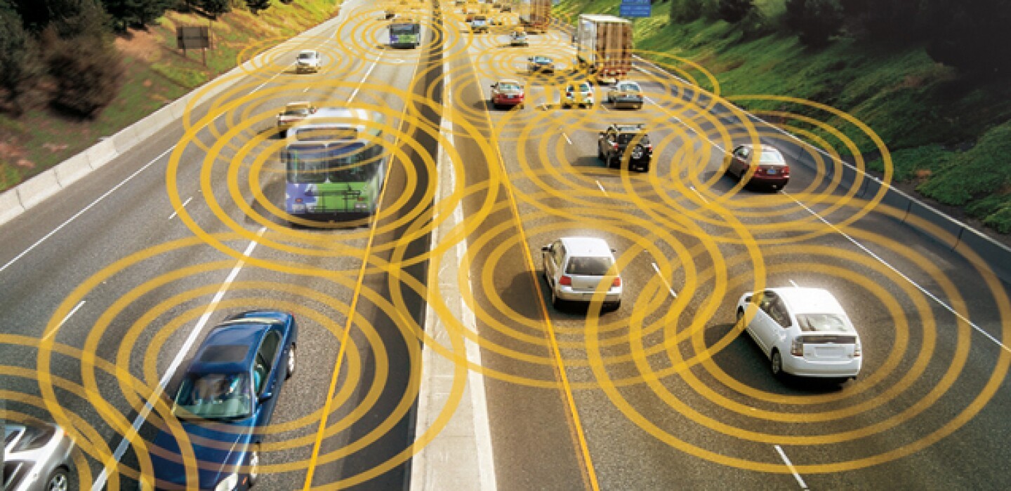 Vehicles equipped with V2X technology driving on a US highway, illustrating how cars communicate with each other and infrastructure.