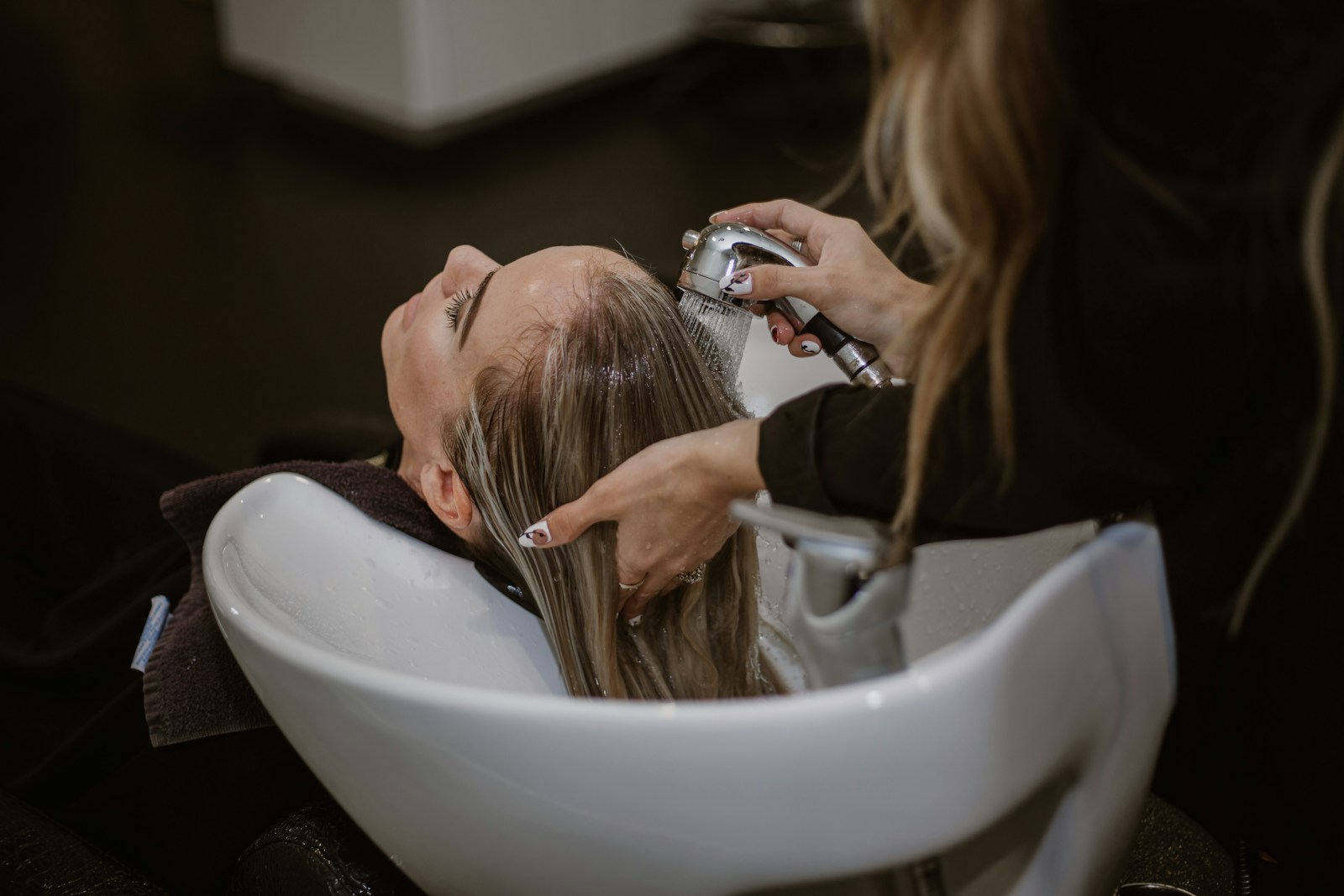 Cabeleireira fazendo corte em cliente em salão de beleza.