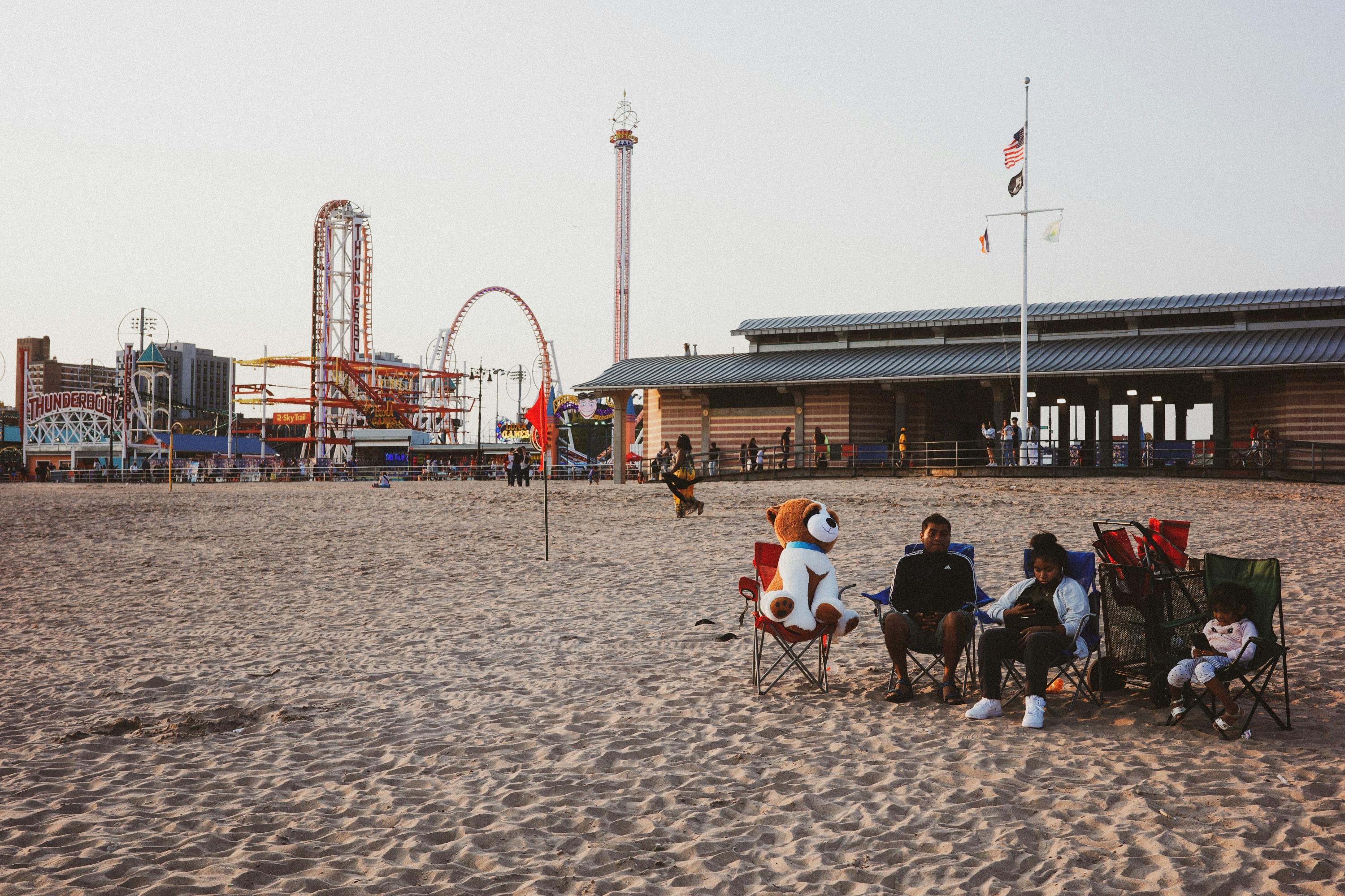 Family relaxing on Coney Island beach – surfboard rental in new-york.