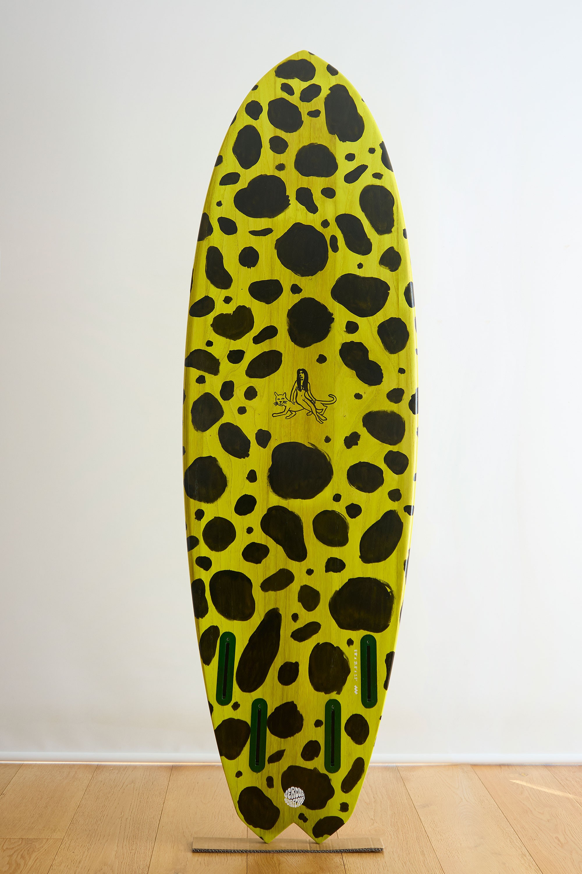 Wooden surfboard with painted leopard spots and artwork