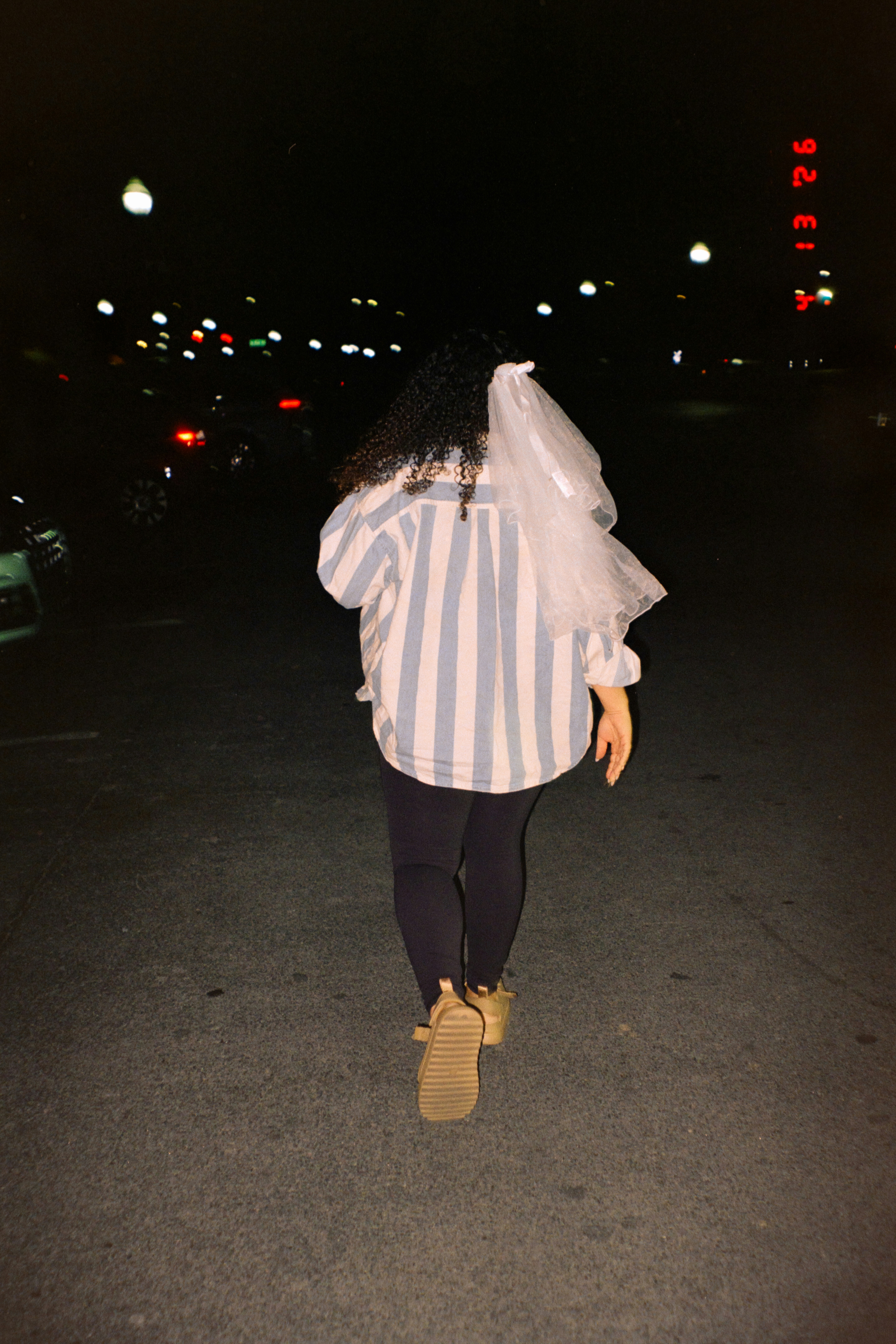 Woman wearing a veil walking at night