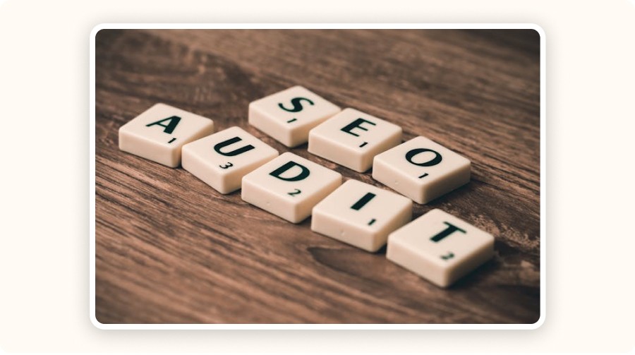 Scrabble tiles spelling “SEO” and “AUDIT” on a wooden surface — representing backlink analysis.