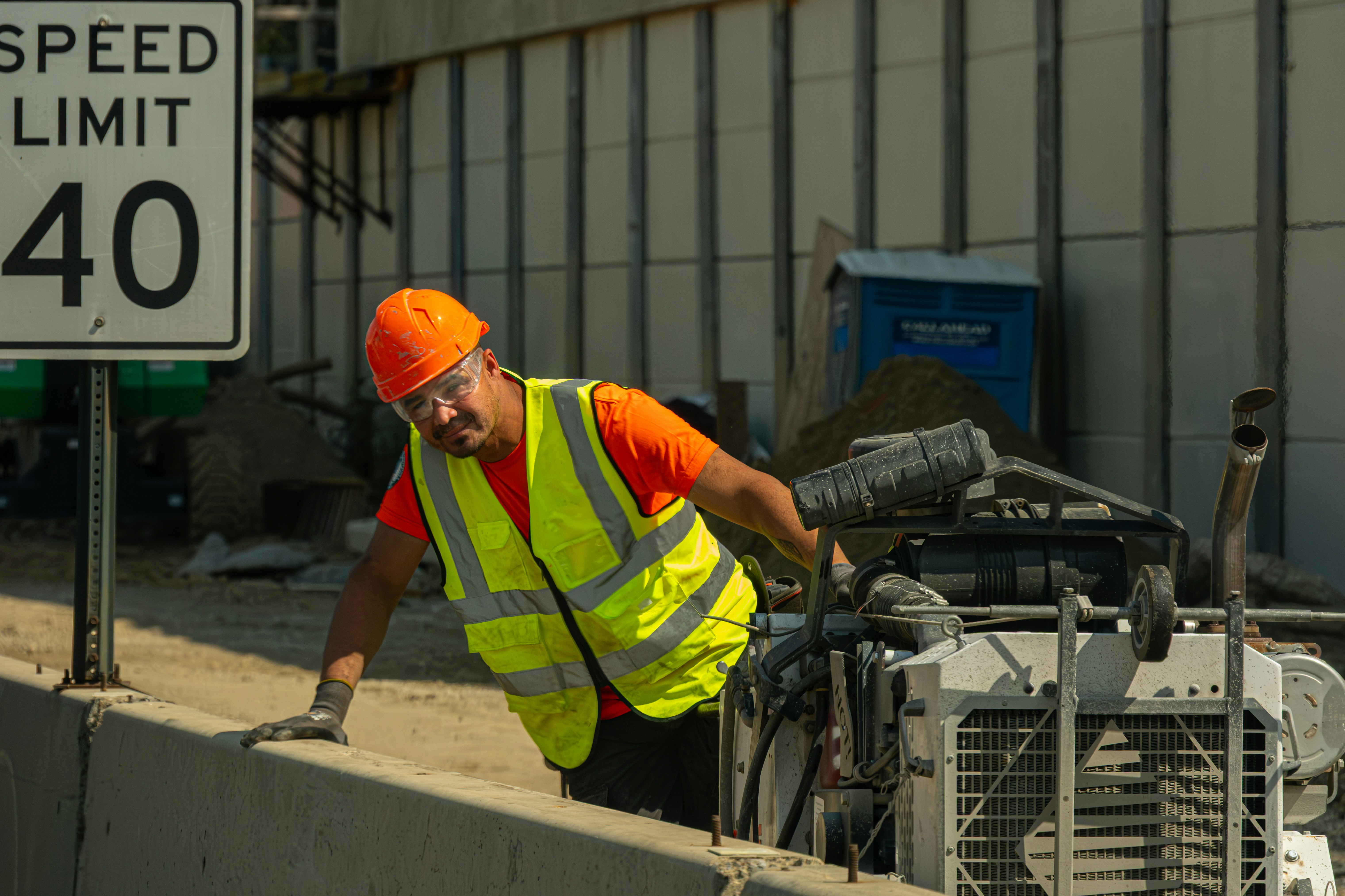 Construction worker in safety vest near speed limit sign