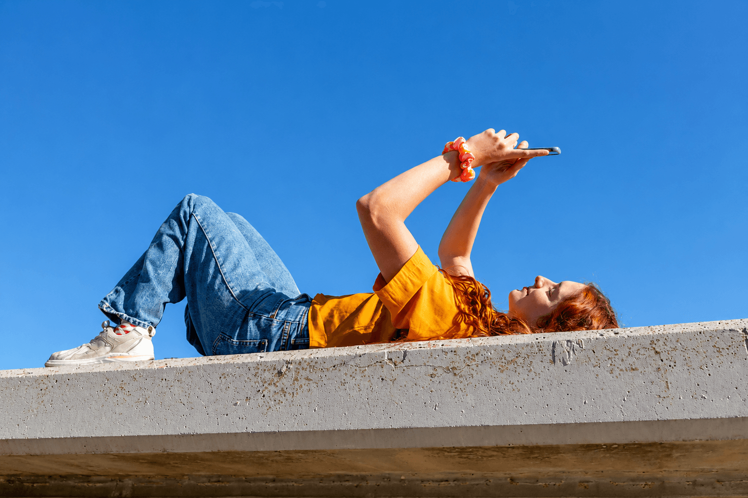woman holding a phone and man looking at the phone. both are smiling