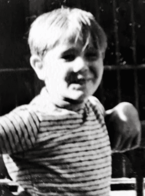 niño rubio con pelo medio y camisa de rayas