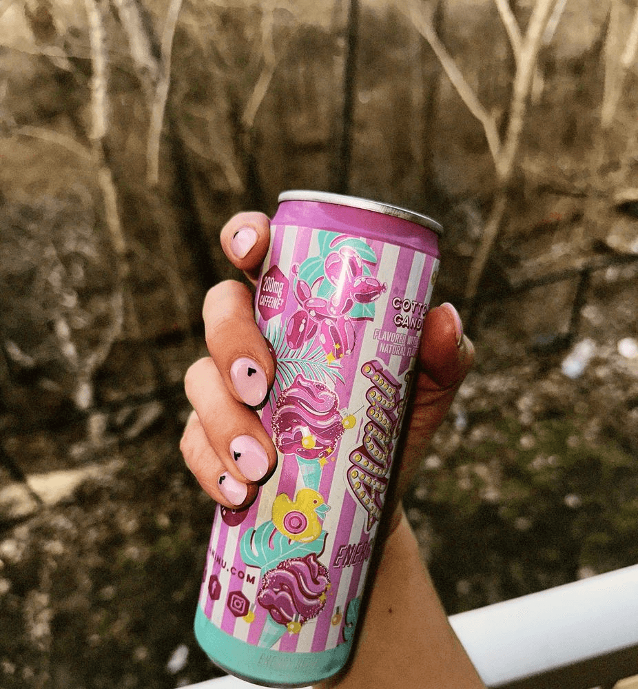 Hand with pink swirl nails and rings in car