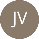 a woman wearing sunglasses standing in front of a body of water