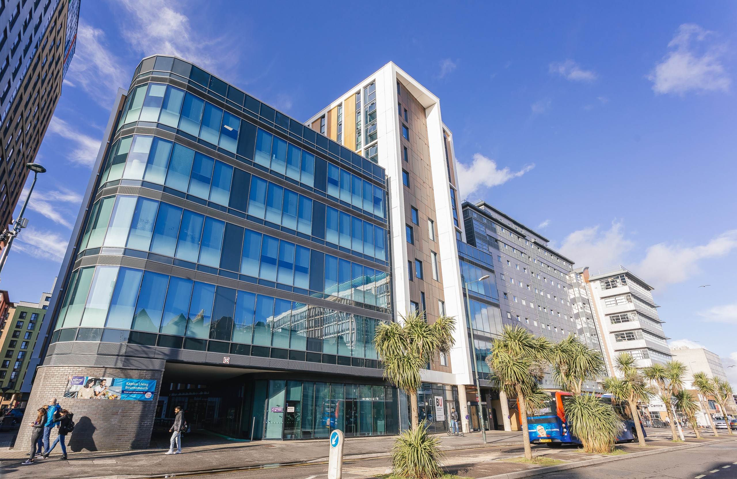 A modern glass fronted building with a clear blue sky