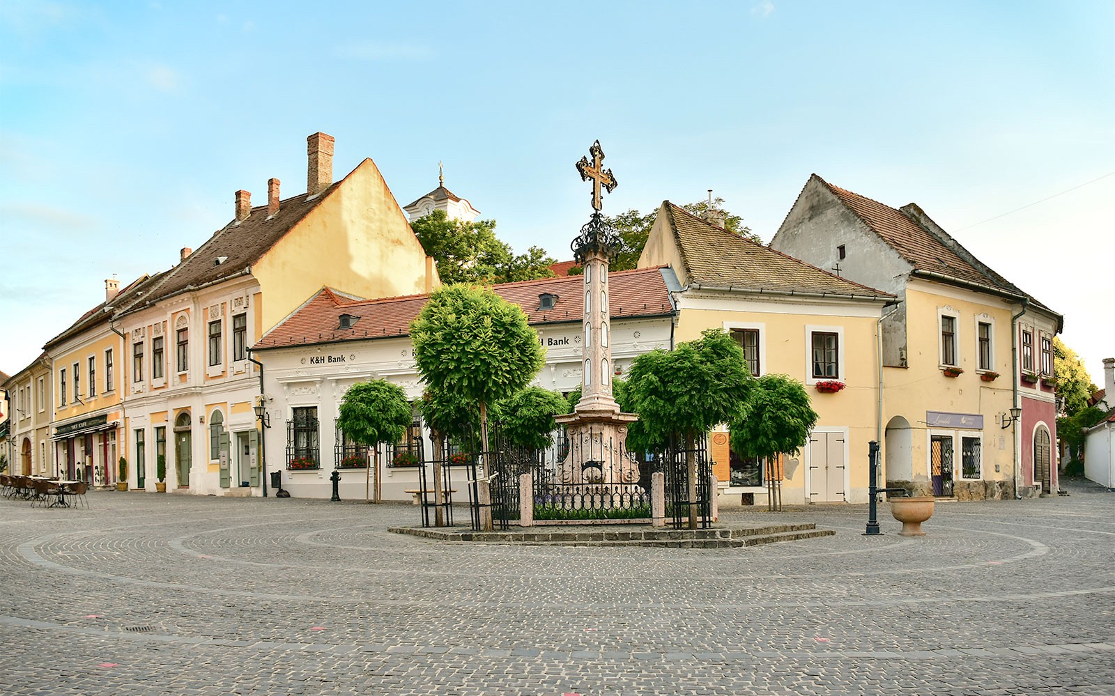 Szentendre town square with historic buildings and a central cross monument.