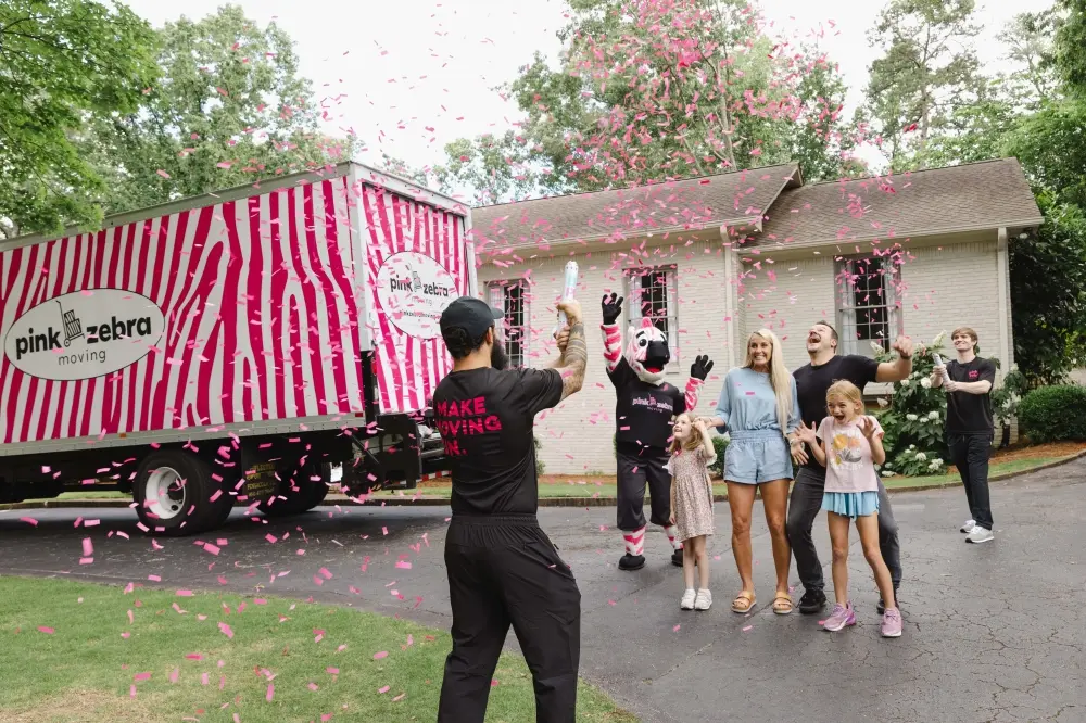 Pink Zebra Moving confetti celebration with mover, mascot, and family