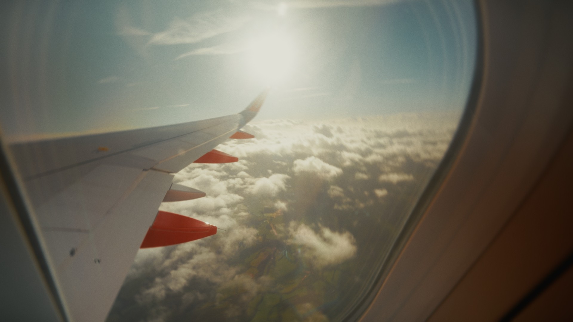 Image looking out of plane window above clouds