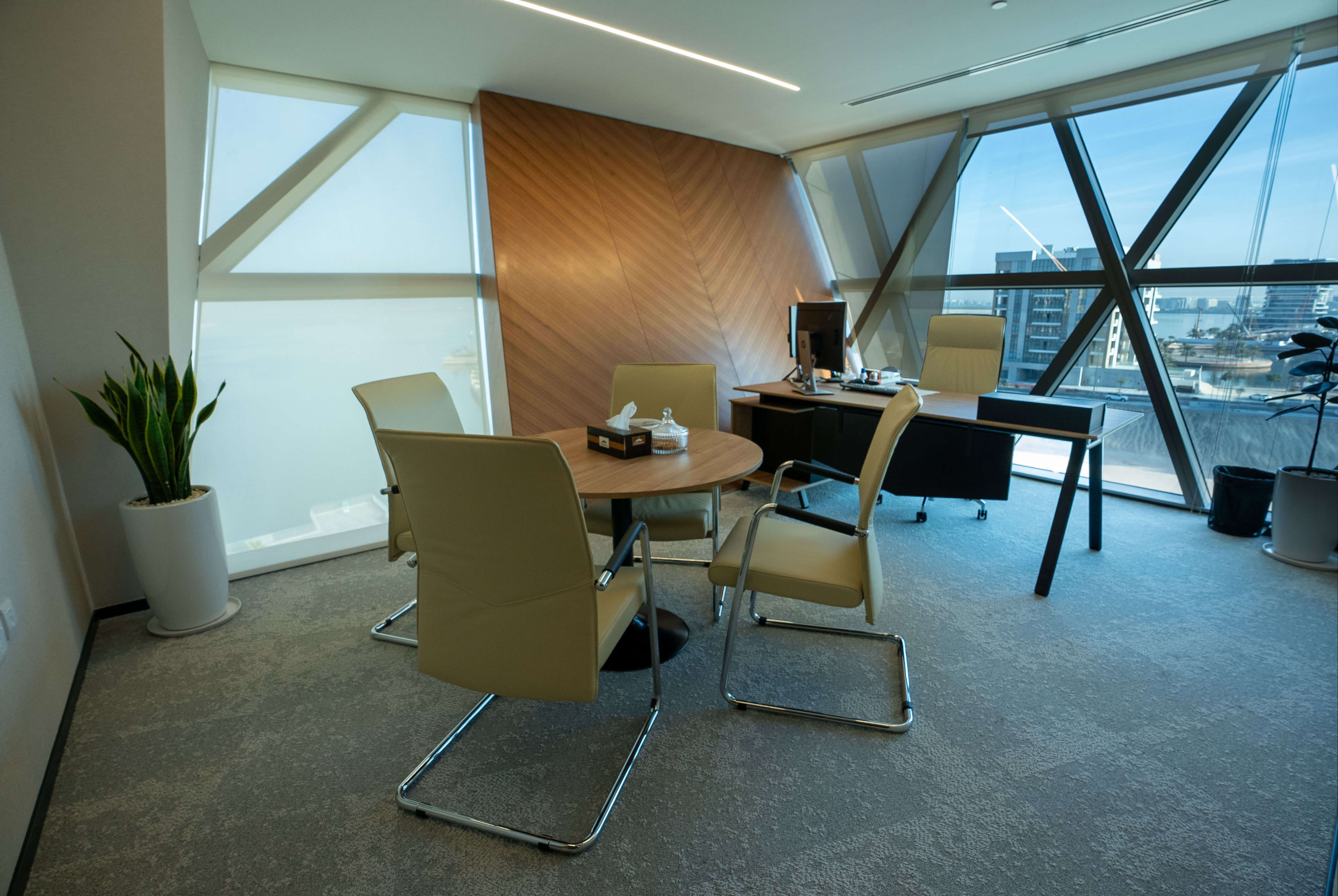 A sophisticated private meeting room with warm lighting, a refined wooden table, and executive chairs.