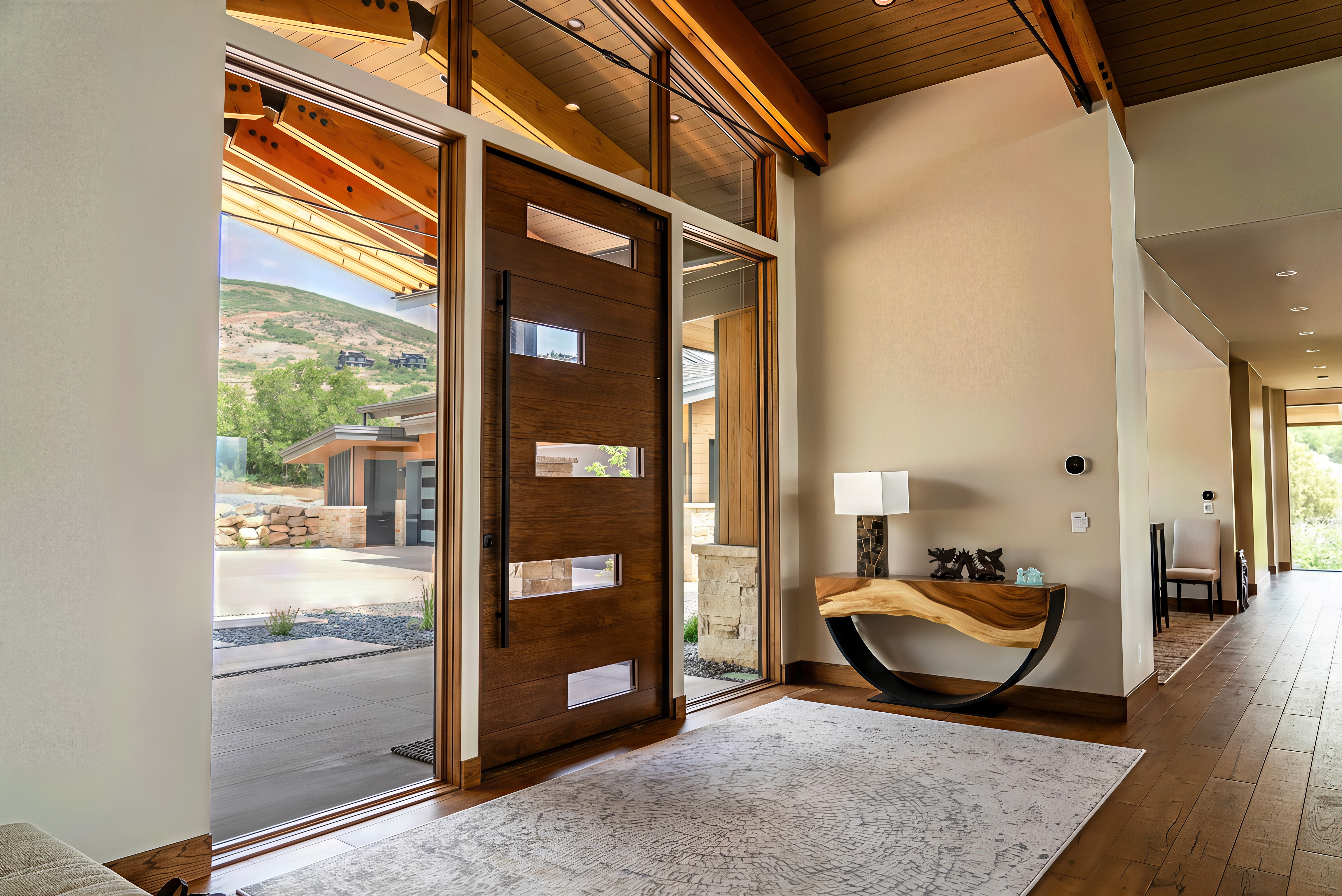 Sunlight streaming through lush green trees, casting shadows on a modern architectural building with glass panels and vertical wooden slats.