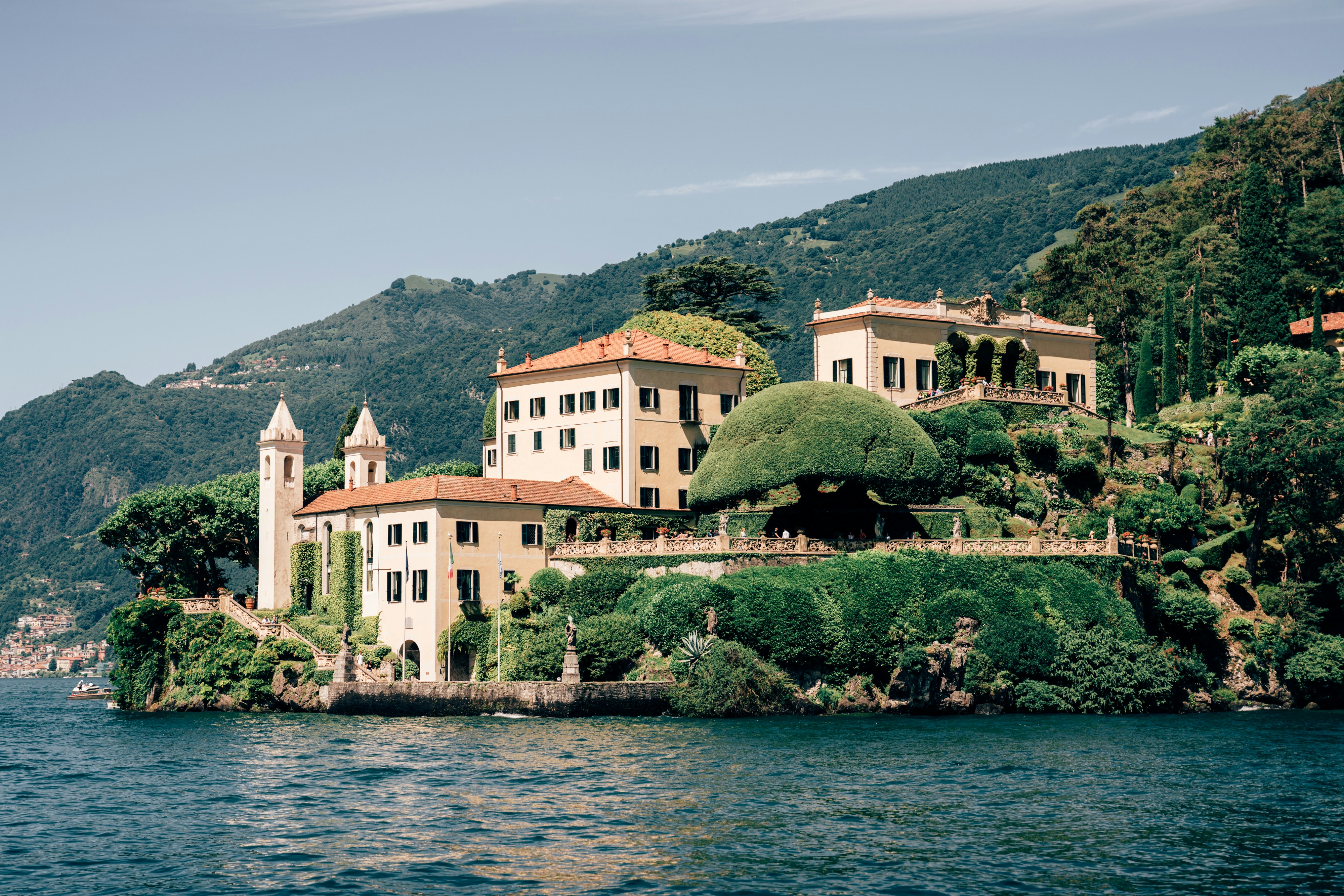 A large white building sitting on top of a lush green hillside