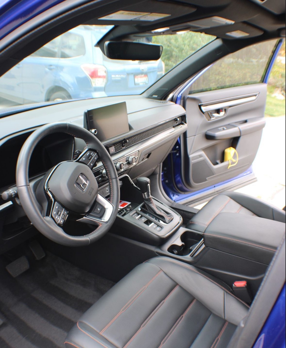woman in blue jacket and blue denim jeans standing on brown wooden bridge