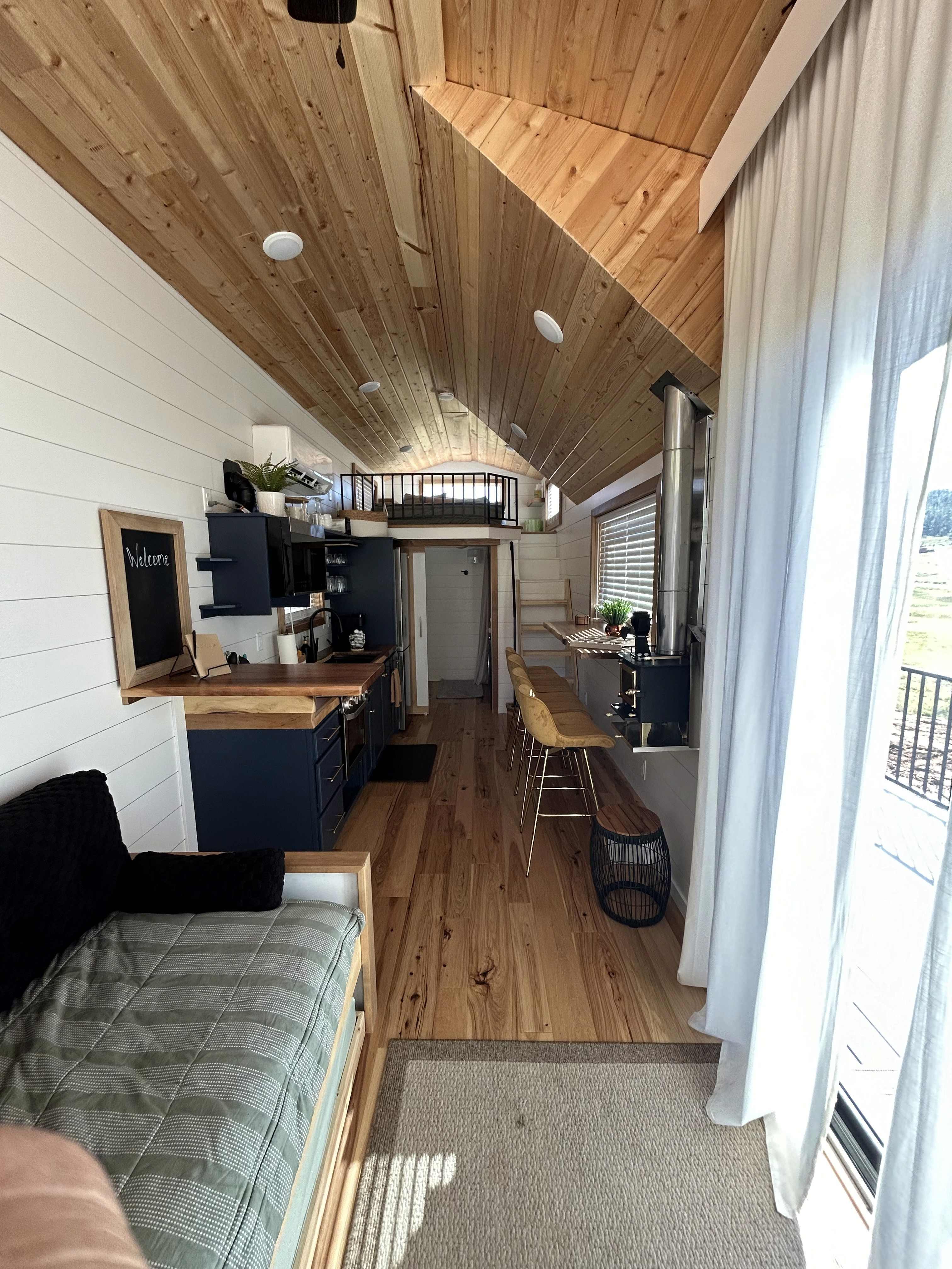 Kitchen in St. George Utah remodel with green cabinetry and natural wood open shelves by Madsen Homes